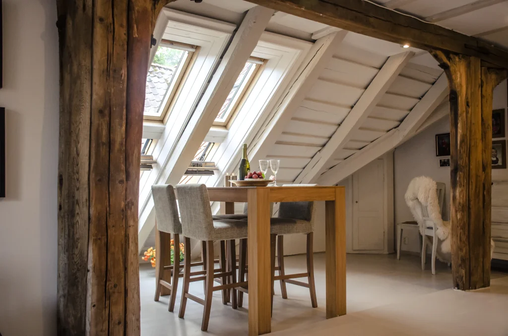 Loft room with exposed beams and rooflights