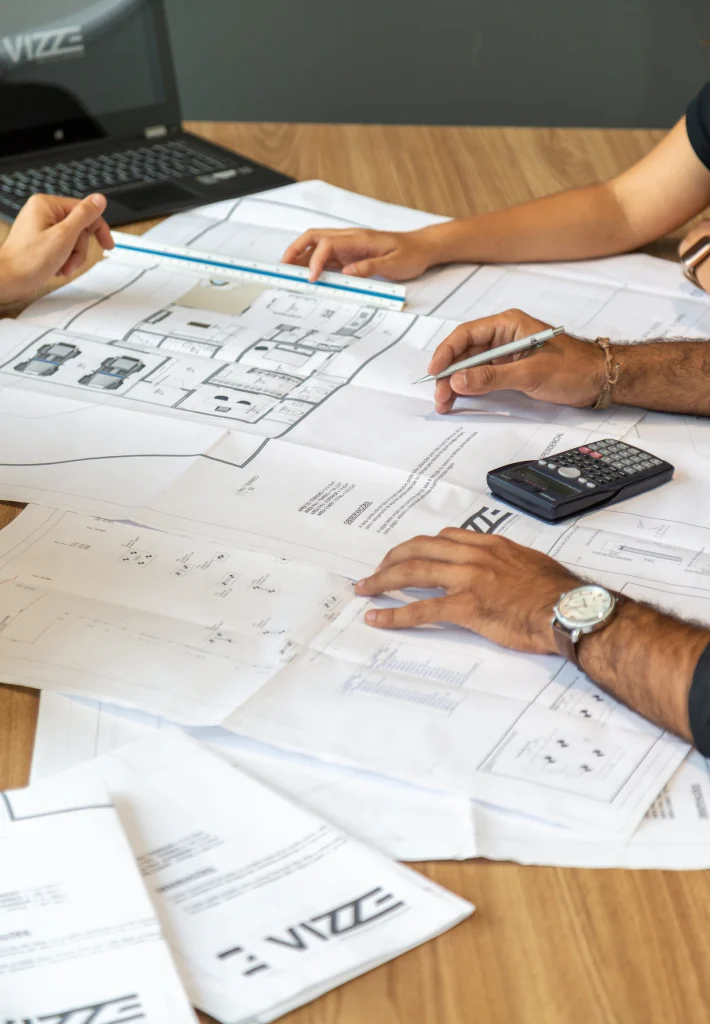 People reviewing architectural plans on a desk
